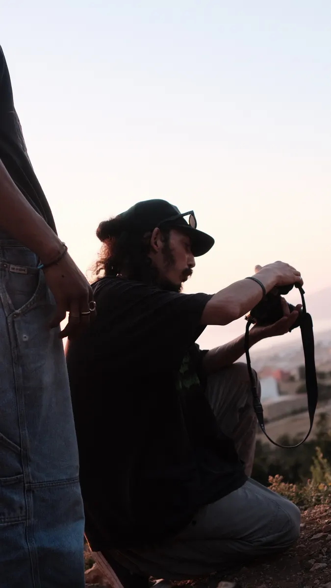 Achraf framing a shot on the hill at dusk