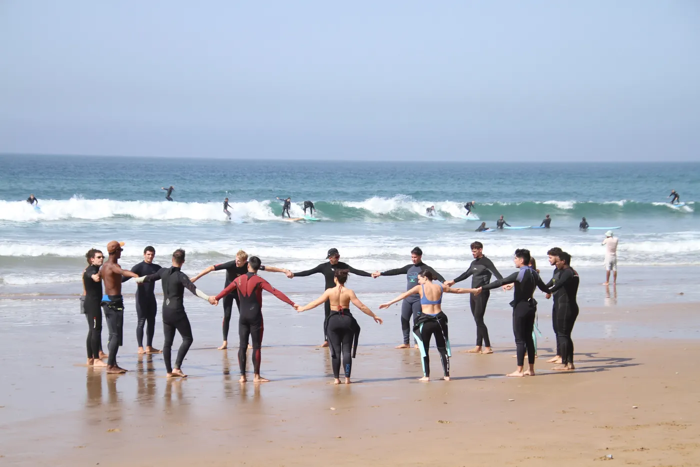 A circle warm-up on the beach before the session